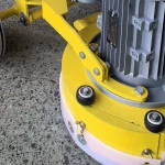 Lower grinding-head guard and wheel area — detail cropped from the source photograph, not another camera angle.