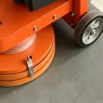 Lower head cover and transport wheel — detail cropped from the source photograph, not another camera angle.